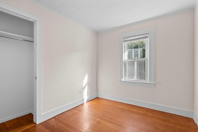 unfurnished bedroom with a closet, ornamental molding, and light hardwood / wood-style flooring