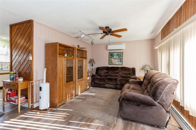 living room featuring a baseboard heating unit, plenty of natural light, a wall unit AC, and dark hardwood / wood-style floors