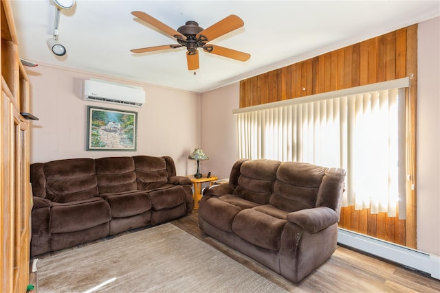 living room with a wall mounted air conditioner, light hardwood / wood-style flooring, baseboard heating, track lighting, and ceiling fan