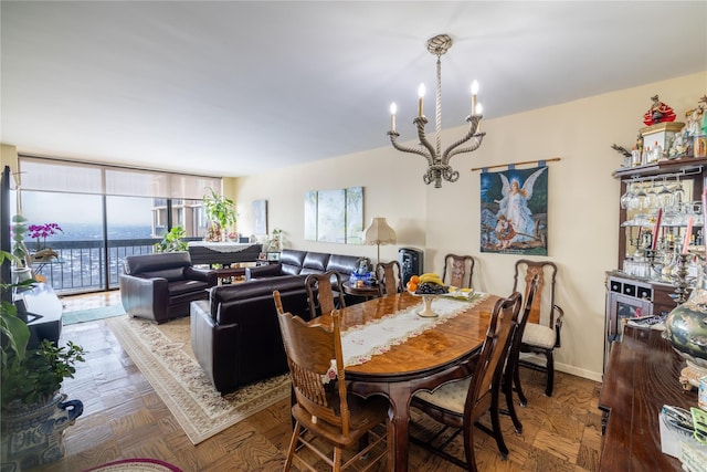 dining room with parquet floors, a wall of windows, and a chandelier