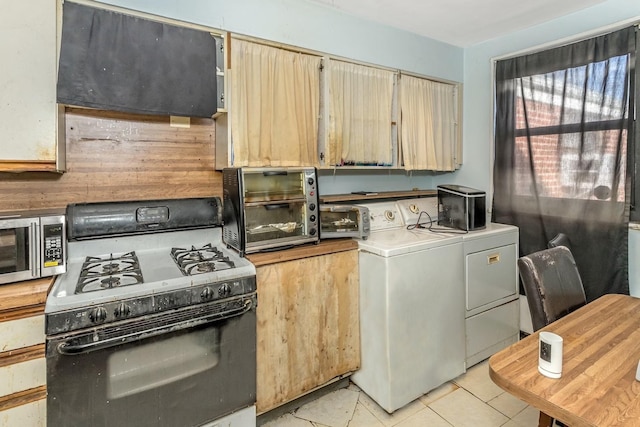 kitchen featuring gas range, independent washer and dryer, and light brown cabinets