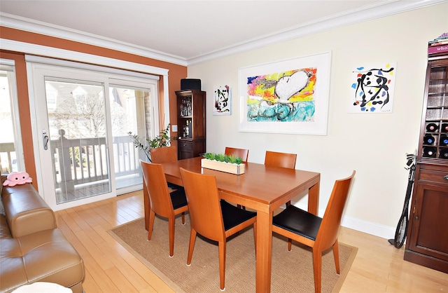 dining room featuring ornamental molding and light hardwood / wood-style floors