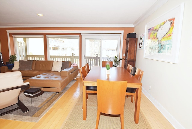 dining area featuring ornamental molding and light wood-type flooring