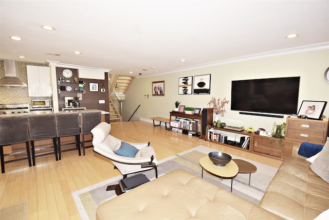 living room featuring ornamental molding and light hardwood / wood-style floors