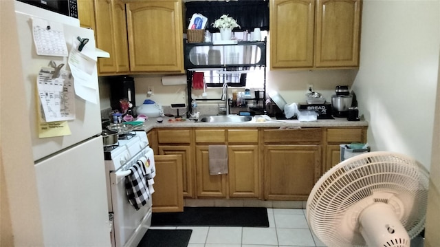 kitchen featuring white appliances, sink, and light tile patterned floors