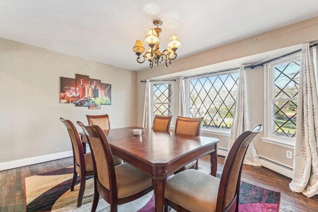 dining room featuring dark hardwood / wood-style floors, a baseboard heating unit, and a chandelier