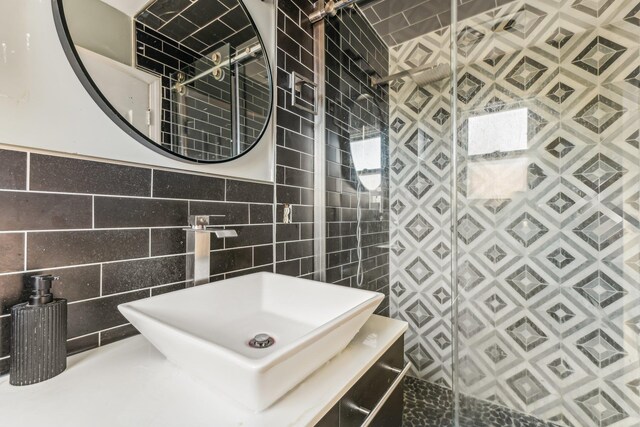 bathroom featuring tiled shower, sink, and tile walls