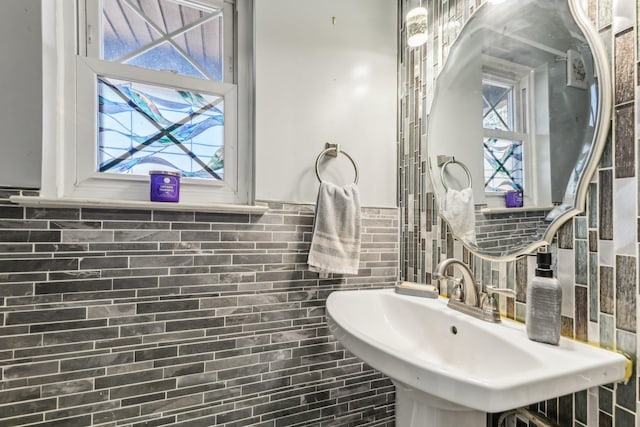 bathroom featuring sink and tile walls