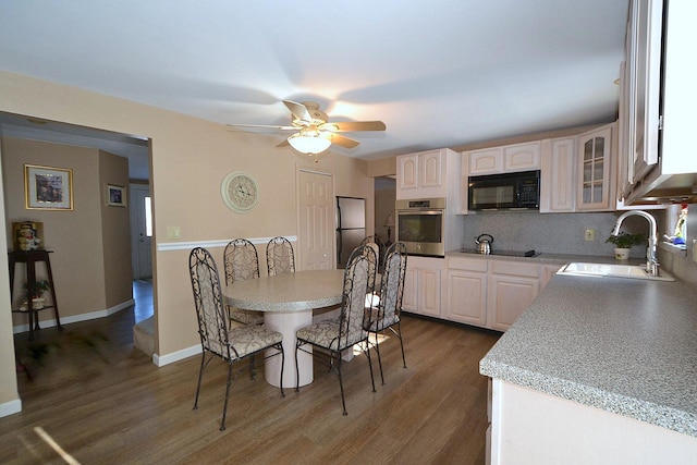 dining room with dark wood-type flooring, ceiling fan, and sink