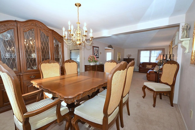 carpeted dining area featuring an inviting chandelier