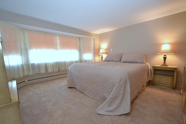 bedroom featuring light carpet and a baseboard heating unit