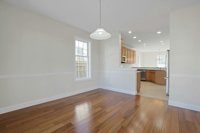 interior space featuring a notable chandelier, plenty of natural light, light hardwood / wood-style floors, and sink