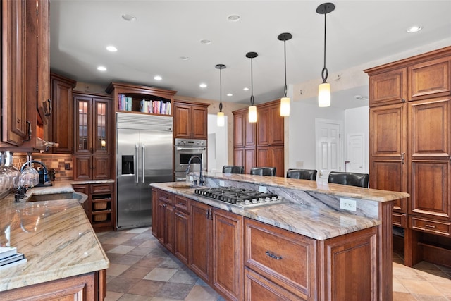 79 Victor Dr, Poughkeepsie, NY 12603 - kitchen with light stone counters, an island with sink, stainless steel appliances, and recessed lighting