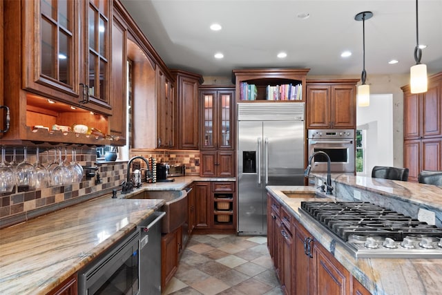 79 Victor Dr, Poughkeepsie, NY 12603 - kitchen featuring built in appliances, decorative backsplash, light stone countertops, and a sink