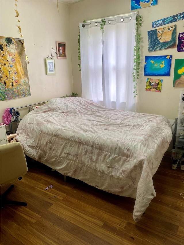 bedroom with dark hardwood / wood-style flooring