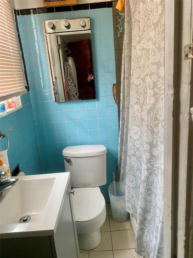 bathroom featuring tile patterned flooring, vanity, tile walls, and toilet