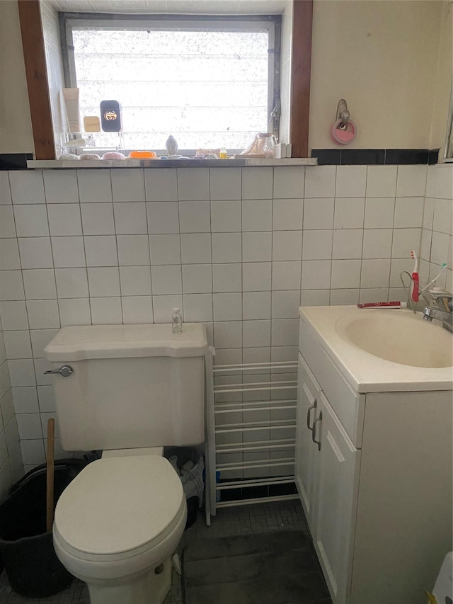 bathroom with vanity, tile walls, and toilet