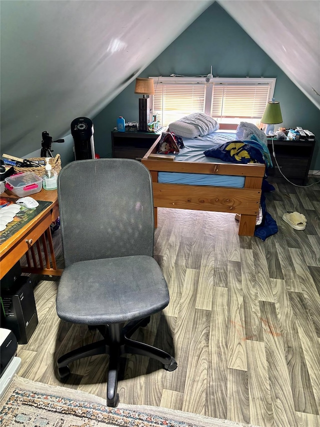 bedroom with lofted ceiling and wood-type flooring