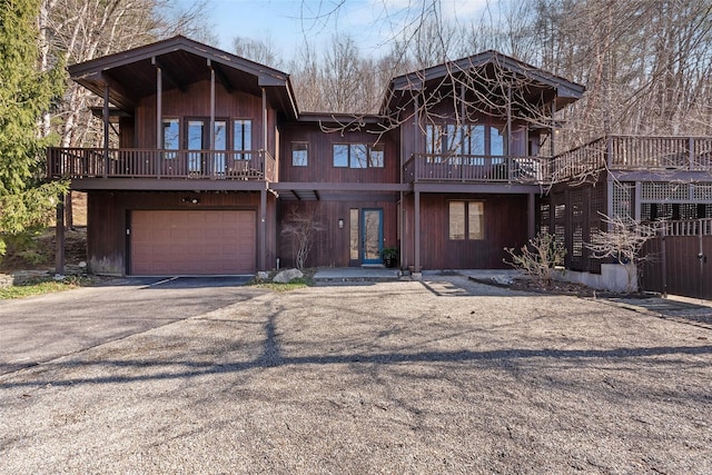 chalet / cabin featuring aphalt driveway and an attached garage