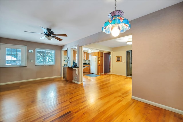 unfurnished living room with ceiling fan and light hardwood / wood-style floors