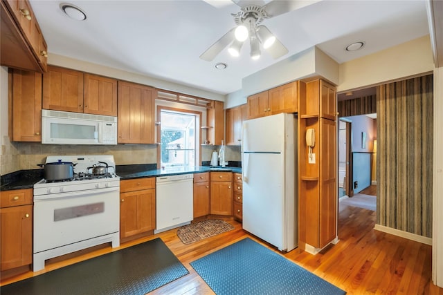 kitchen with tasteful backsplash, hardwood / wood-style floors, and white appliances