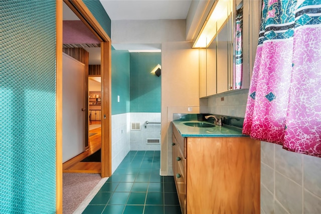 bathroom featuring tile patterned flooring, vanity, and tile walls