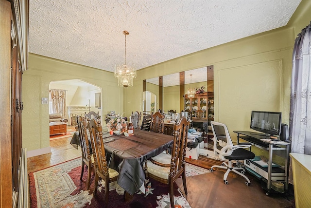 dining room with hardwood / wood-style floors, a textured ceiling, and a chandelier