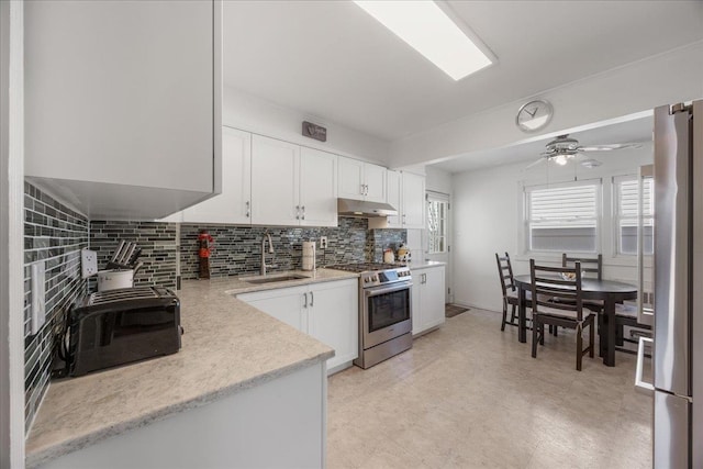 kitchen featuring sink, appliances with stainless steel finishes, ceiling fan, decorative backsplash, and white cabinets