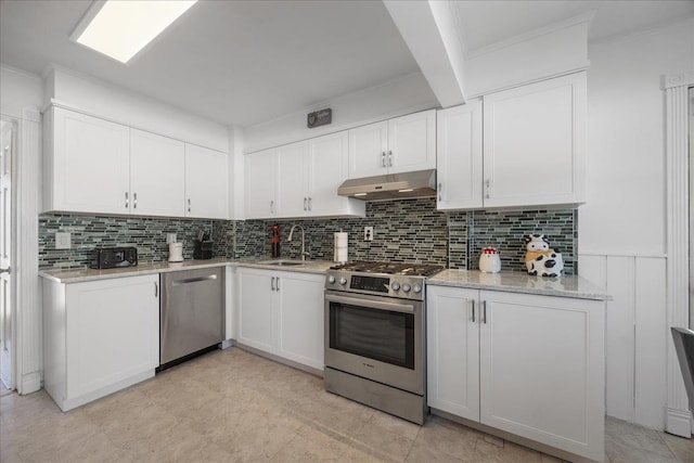 kitchen featuring sink, white cabinetry, stainless steel appliances, light stone countertops, and decorative backsplash