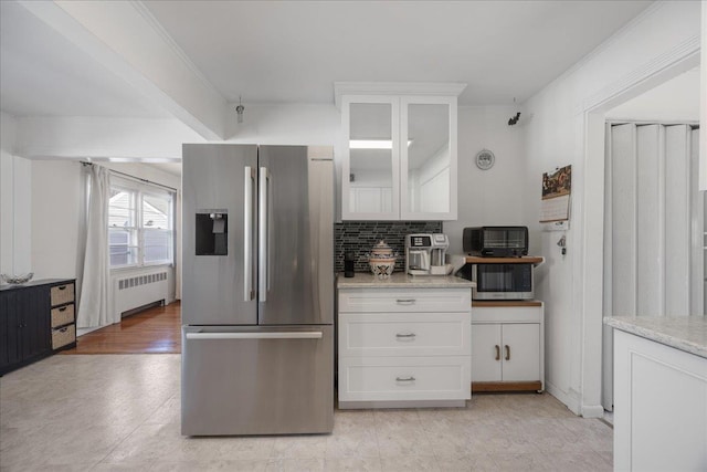 kitchen with radiator heating unit, white cabinets, decorative backsplash, stainless steel appliances, and crown molding