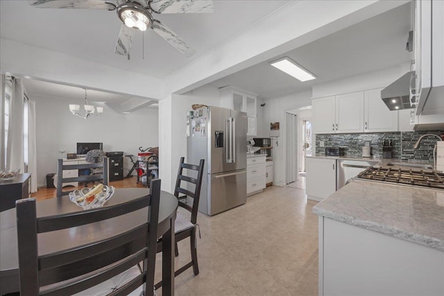 dining space featuring ceiling fan with notable chandelier