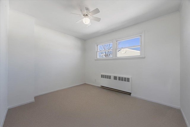 carpeted empty room featuring ceiling fan and radiator