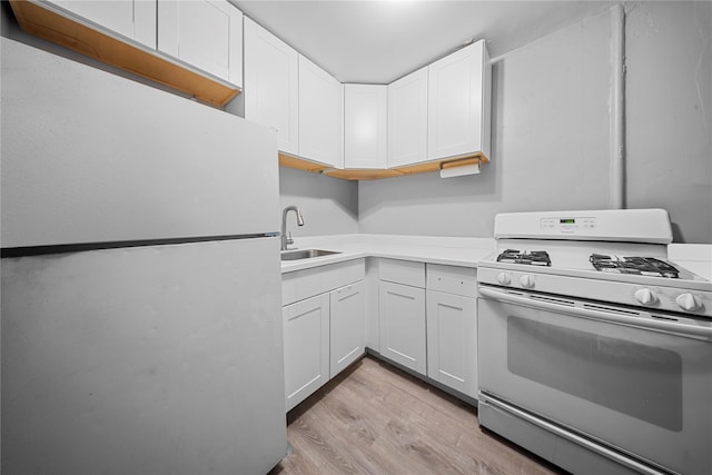 kitchen with sink, white cabinetry, fridge, light hardwood / wood-style floors, and white range with gas cooktop