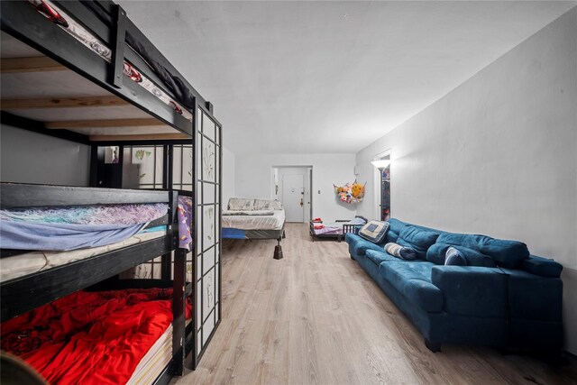 bedroom featuring a barn door and light hardwood / wood-style flooring