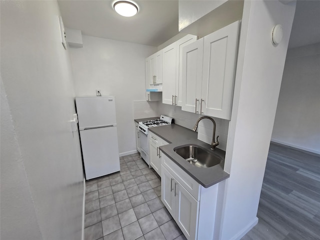 kitchen with white appliances, sink, decorative backsplash, and white cabinets