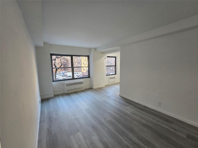 empty room featuring dark hardwood / wood-style flooring and radiator