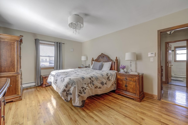 bedroom with a baseboard heating unit and light wood-type flooring