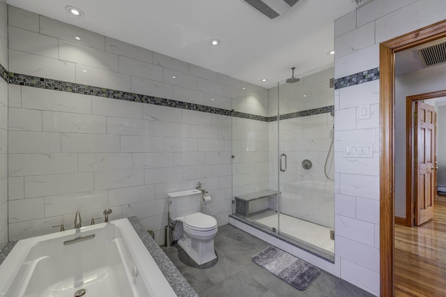 bathroom featuring plus walk in shower, tile walls, and toilet