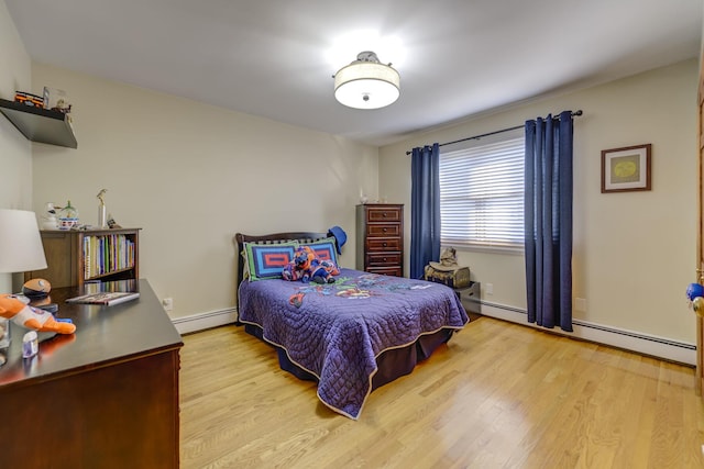 bedroom with a baseboard heating unit and light hardwood / wood-style floors