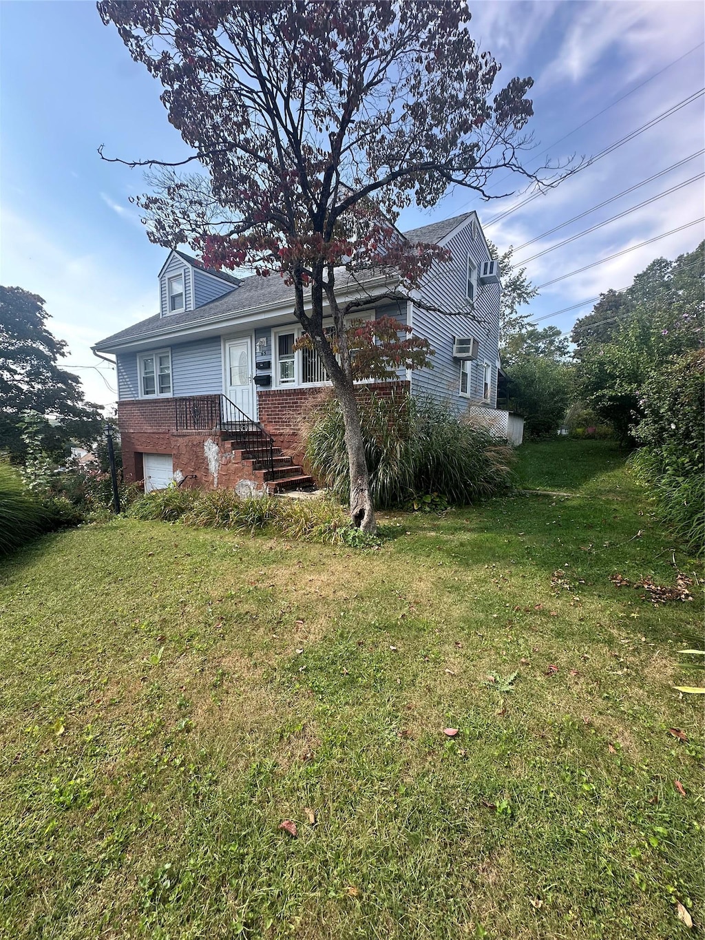 exterior space featuring a garage and a lawn