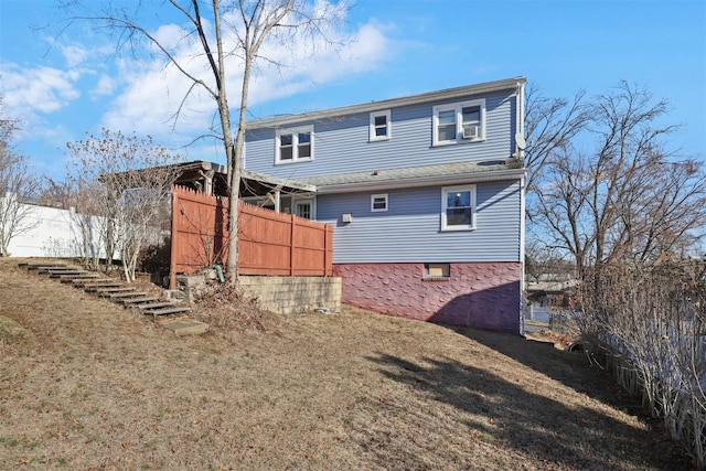 rear view of property with cooling unit and a yard