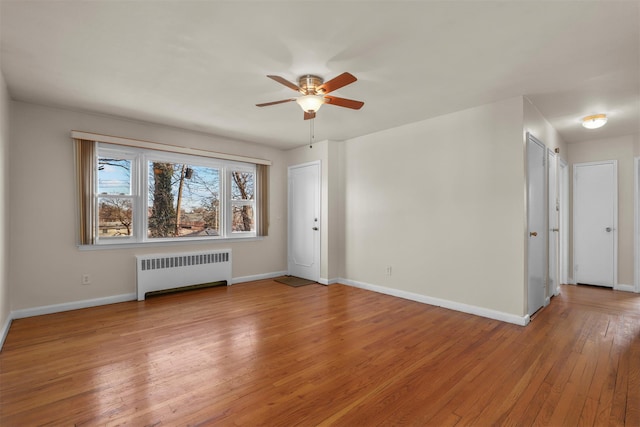 unfurnished living room featuring radiator heating unit, ceiling fan, and light hardwood / wood-style flooring