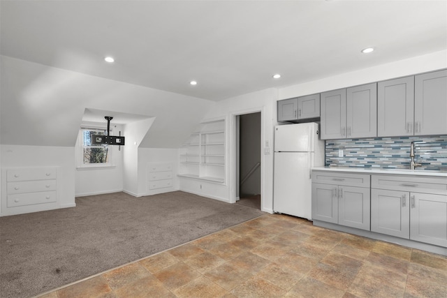 kitchen with built in features, sink, gray cabinetry, white fridge, and light carpet