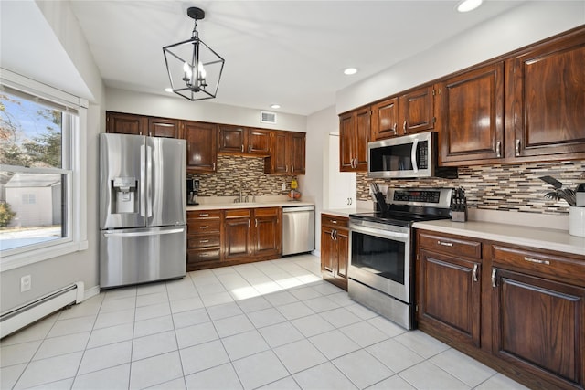 kitchen with light tile patterned flooring, decorative light fixtures, tasteful backsplash, a baseboard radiator, and stainless steel appliances