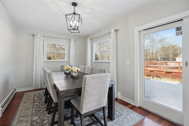 dining area featuring baseboard heating, a chandelier, and dark wood-type flooring