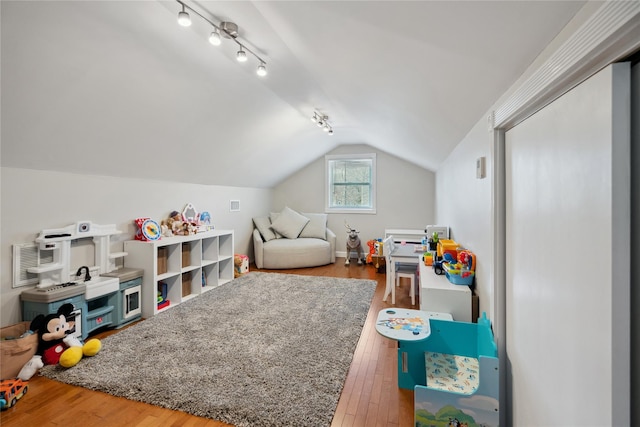 game room with lofted ceiling, hardwood / wood-style floors, and rail lighting