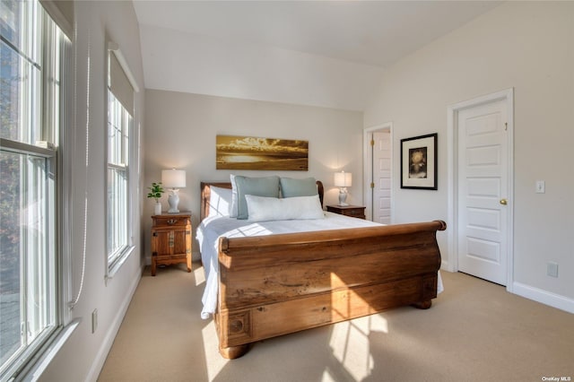 bedroom featuring light carpet and vaulted ceiling