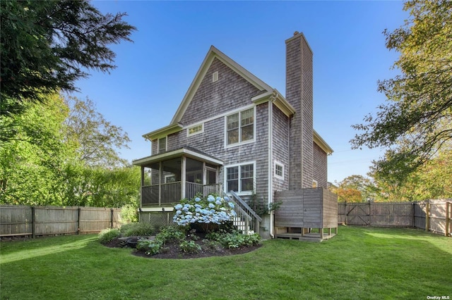 rear view of house with a yard and a sunroom