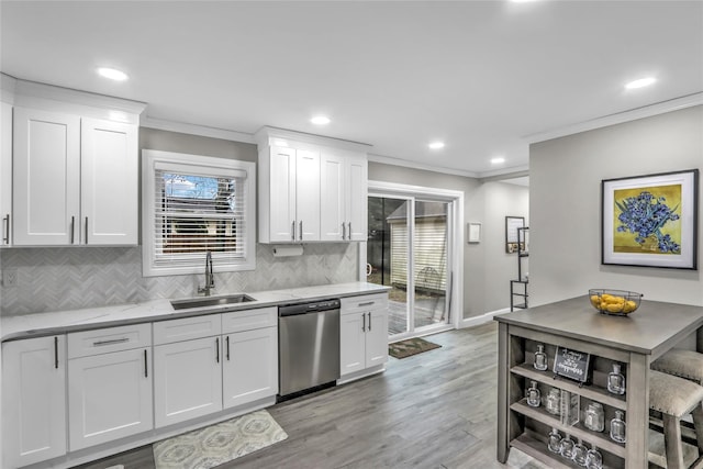 kitchen featuring sink, crown molding, dishwasher, white cabinetry, and light hardwood / wood-style floors