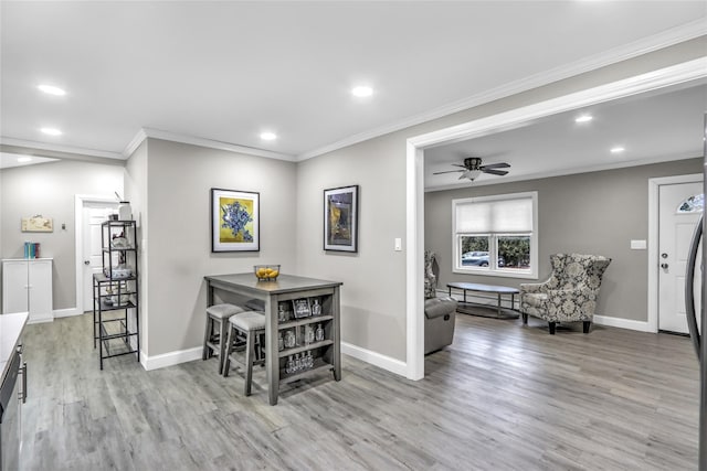 dining space with ornamental molding, ceiling fan, and light hardwood / wood-style flooring